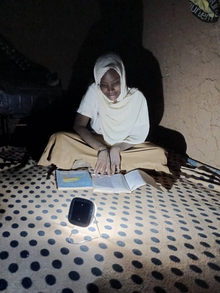 A woman reads using a light