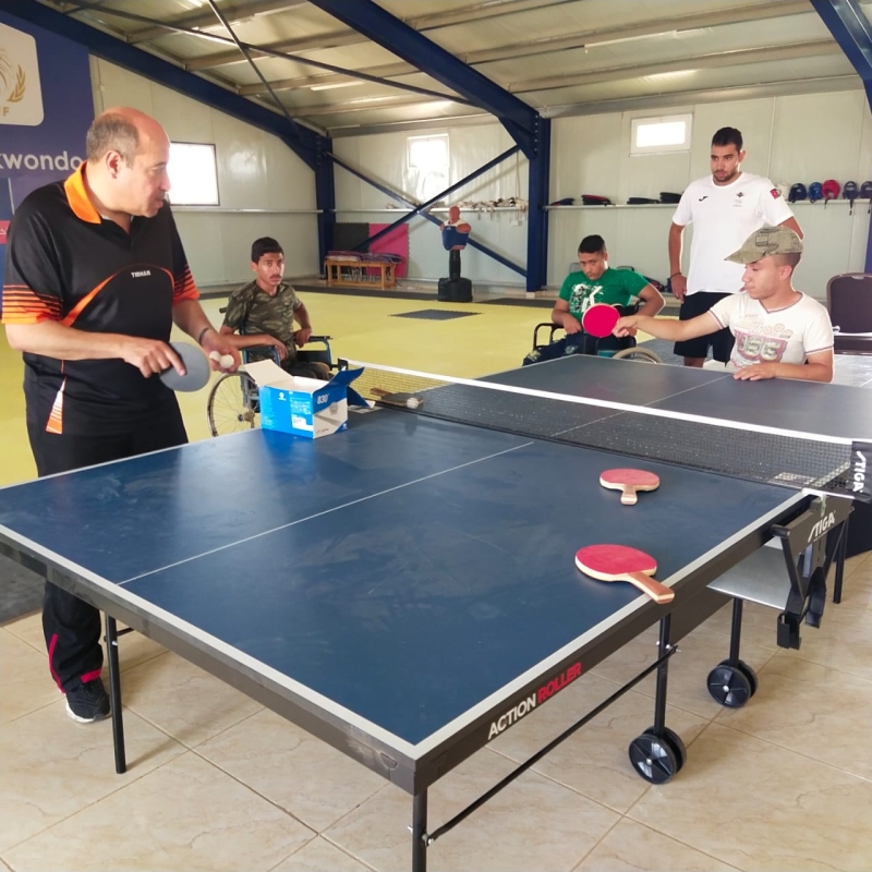 Children in wheelchairs play table tennis