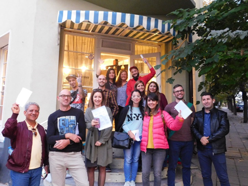 People holding certificates outside a building.