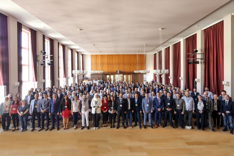 People standing looking at the camera inside a room.