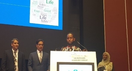 Refugee delivering statement from a podium.