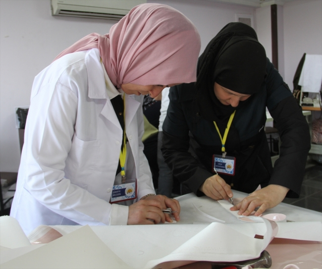 Two women are leaning over a table working together on documents