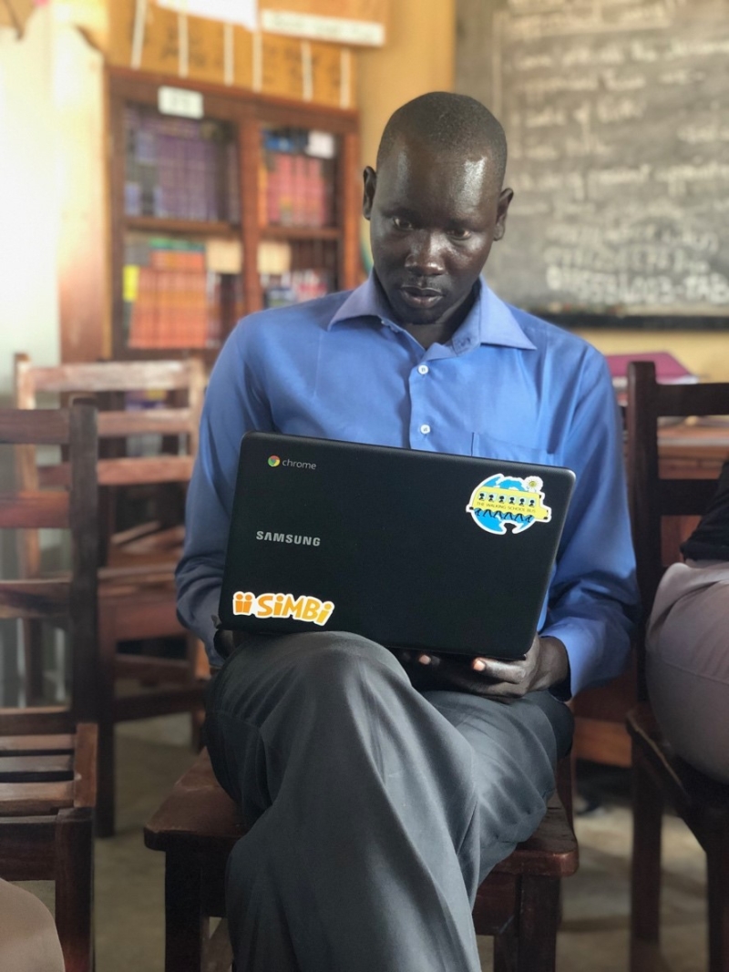 Teacher selecting books on Simbi