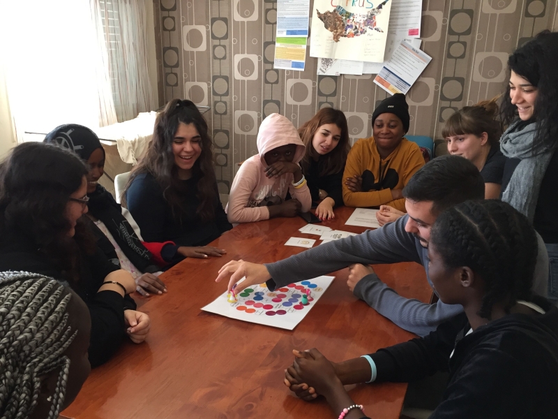 Children and youth playing a game in a table.