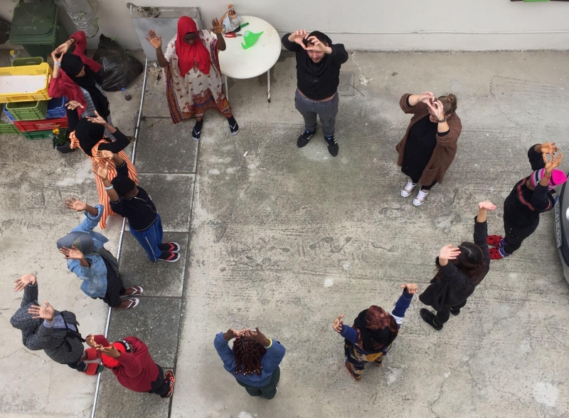 People standing outside with their hands in the air.