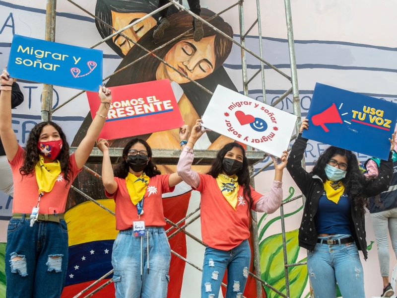 People wearing masks and holding up signs