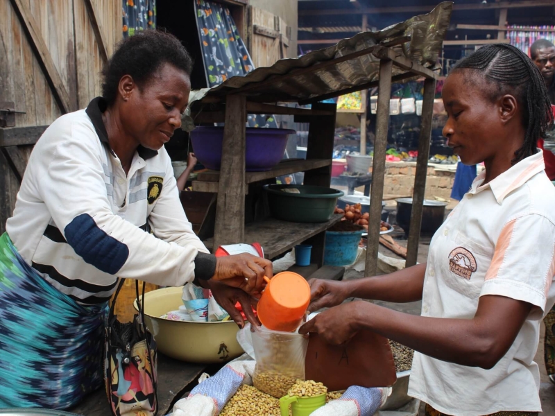 Ortense serving a customer at her market stall