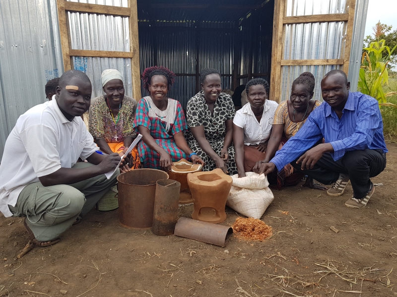 A group of people show cooking pots.