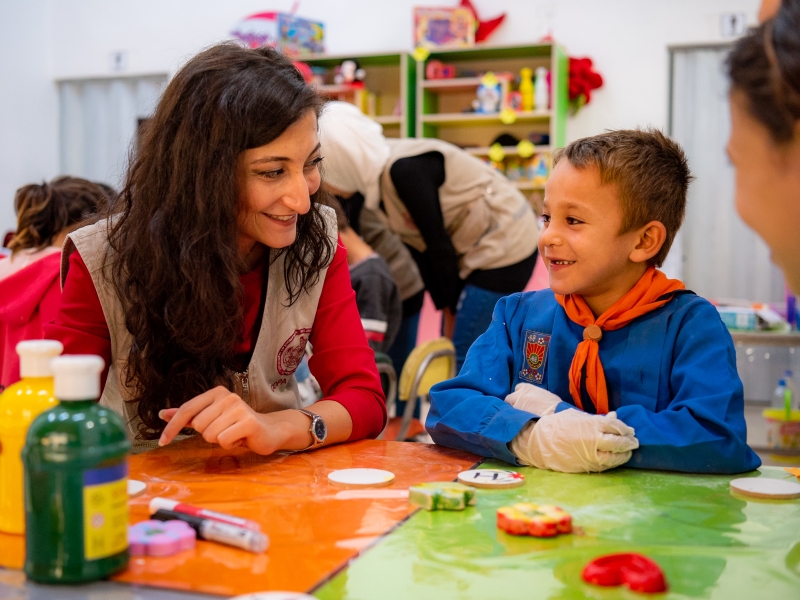 Children with their teacher do painting activities