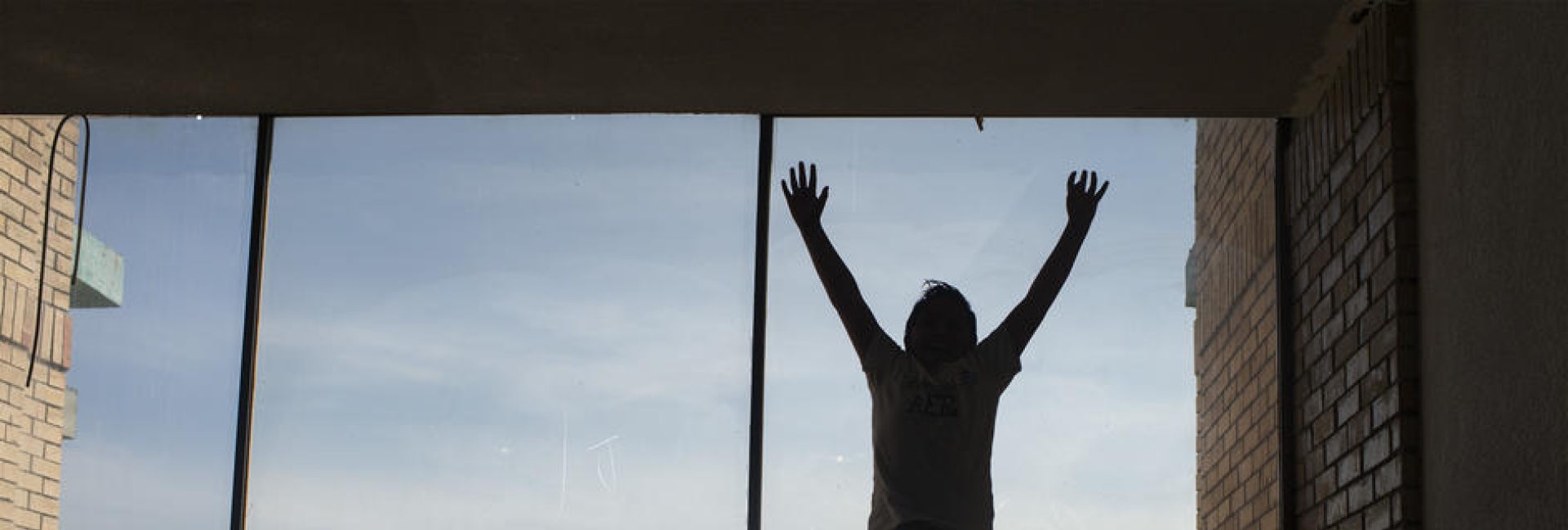 A boy jumps in start of the window