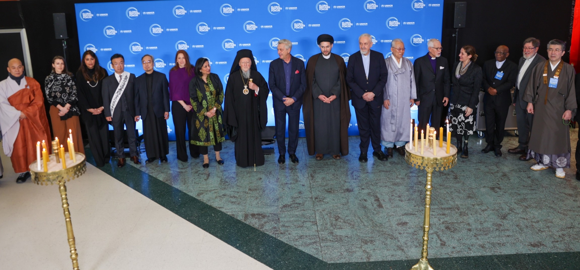 A group photo from the candle lighting ceremony at the Global Refugee Forum 2023 - religious leaders and the High Commissioner stand together in a line