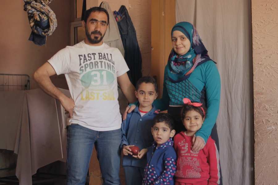 Family smiling and looking at the camera.