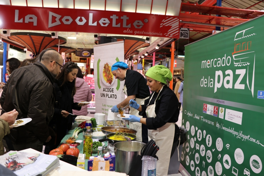 People being served food at a food market.