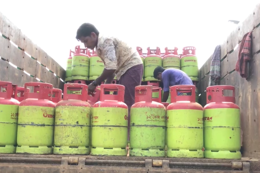 Man in middle of gas containers on top of a truck.