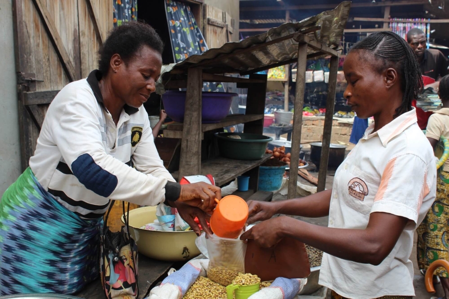 Ortense serving a customer at her market stall