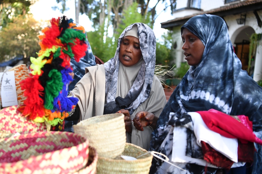 Two ladies shop at a market stall