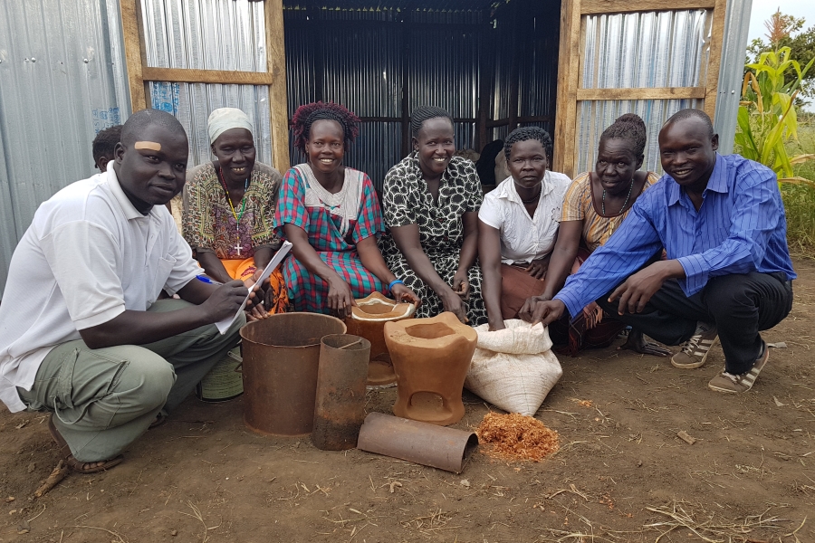 A group of people show cooking pots.