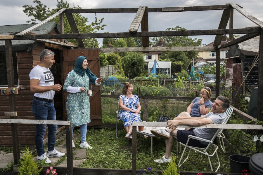 A group of people sitting in a garden smiling