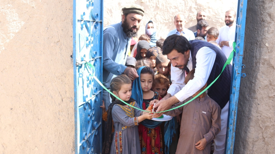 Children and adults cut an inauguration ribbon