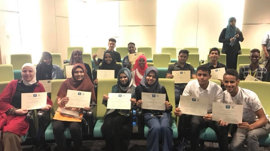 Students hold up their diplomat to the camera