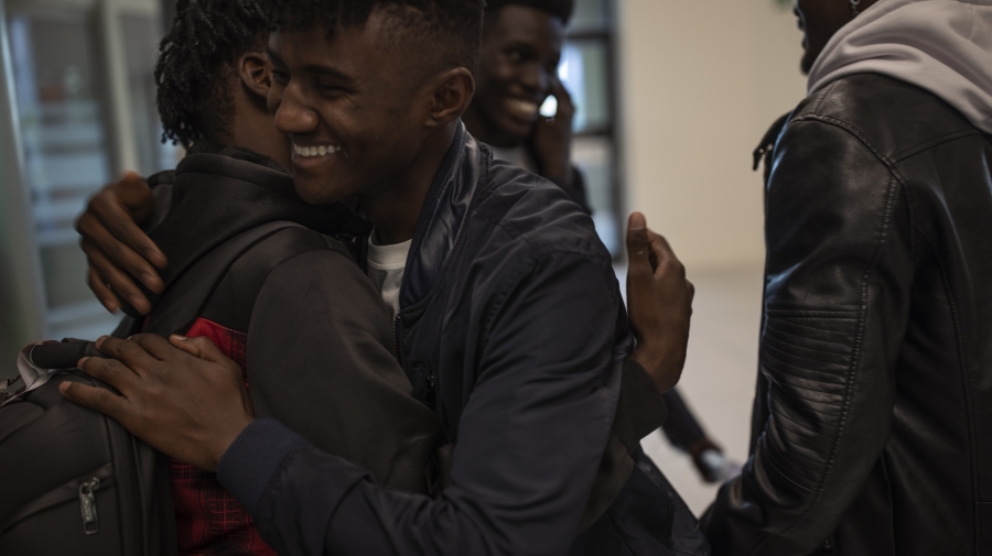Men smiling and hugging