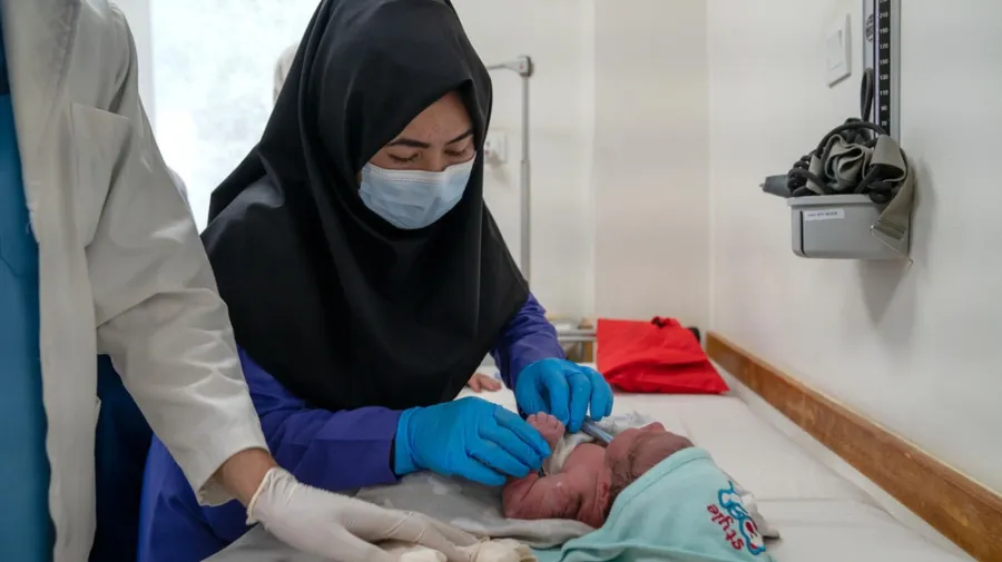 Student midwife Masoma performs checks on a newborn under supervision at the hospital.