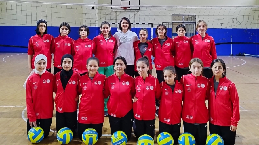 Girls pose on a volley ball court and smile to the camera