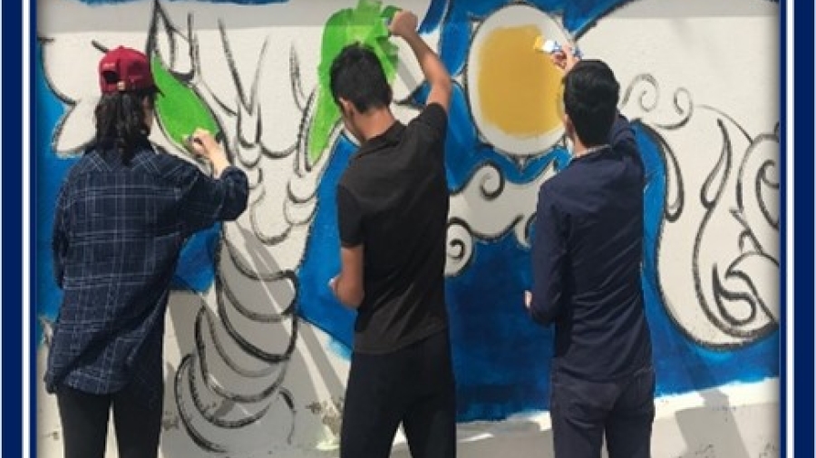 Children with their backs to the camera painting a mural
