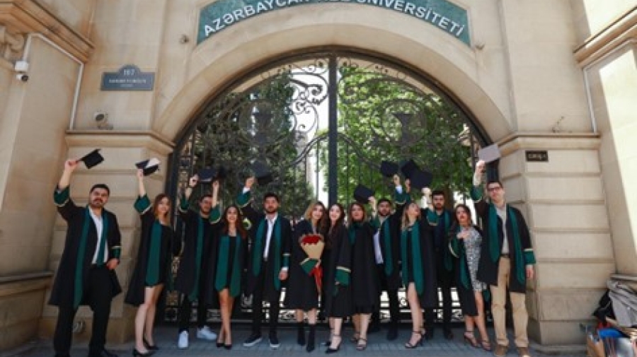 Graduates posing in front of a university