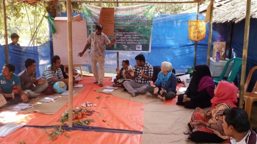 People sitting in a circle in a tent