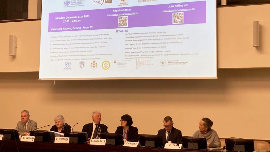 Photo of the panel - six speakers sit in a row with a presentation on a screen behind them