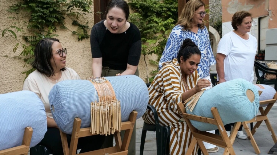 Women making lace demonstrate their craft to onlookers